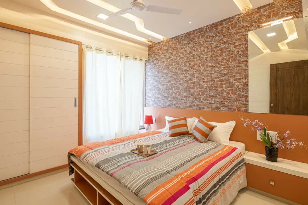 Bedroom with faux brick accent wall and orange headboard ledge