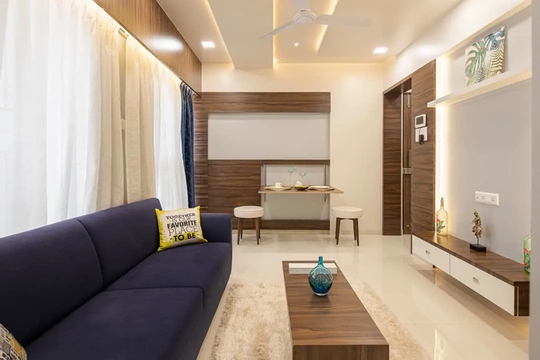 Living room with navy sofa and wall mounted folding dining table