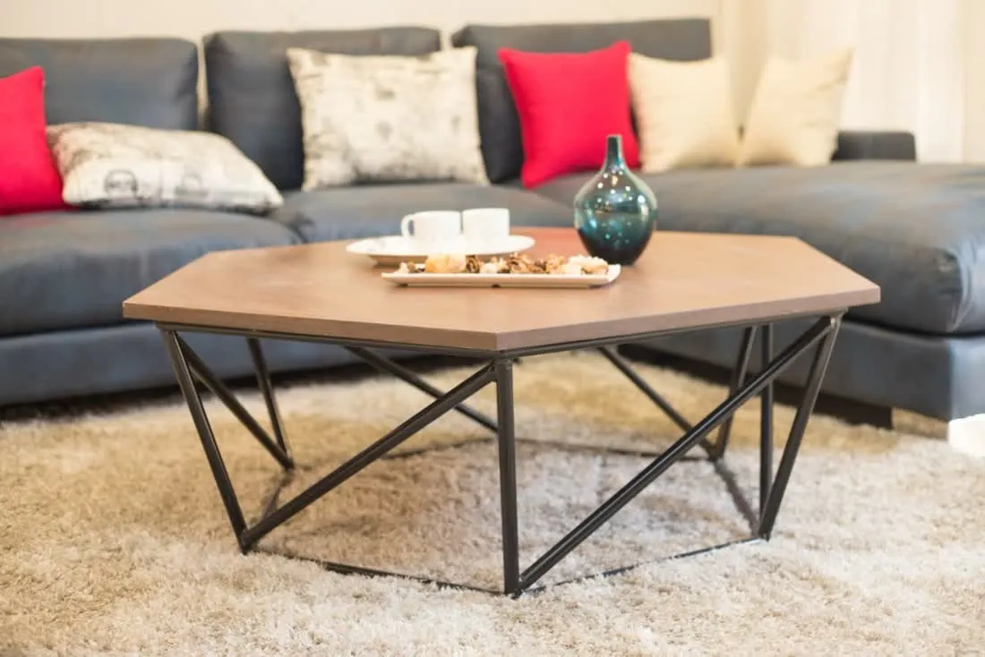 Hexagonal coffee table detail with blue leather sofa behind