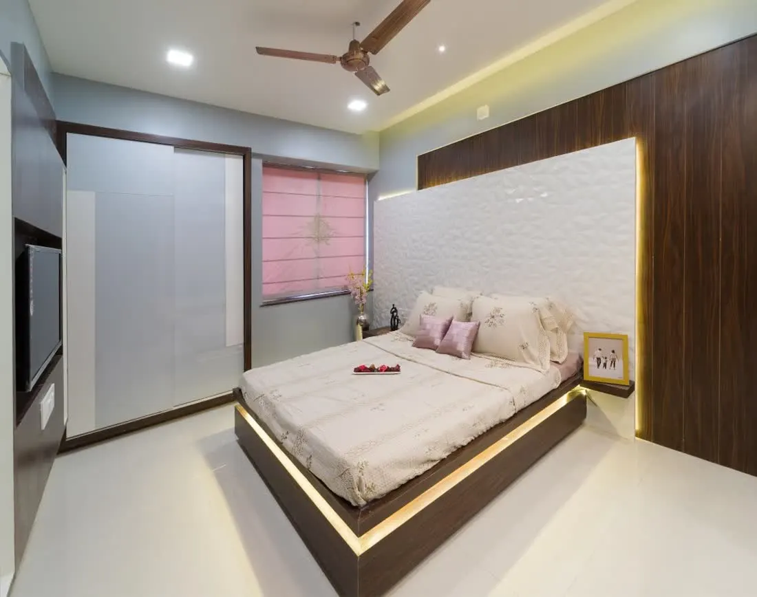 Master bedroom with panelled headboard and warm lighting